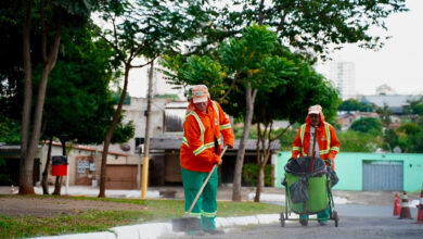 Imagem ilustrativa: Dois agentes da Comurg ( Companhia de Urbanização de Goiânia) realizando serviços de limpeza urbana em uma rua.