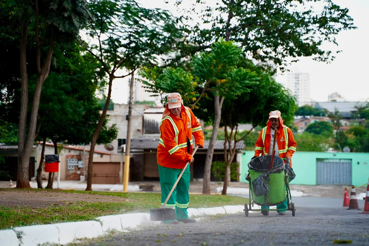 Imagem ilustrativa: Dois agentes da Comurg ( Companhia de Urbanização de Goiânia) realizando serviços de limpeza urbana em uma rua.