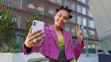 Imagem ilustrativa de uma mulher tirando uma selfie com um celular, ou seja, tirando uma foto de si mesma com uma celular.
